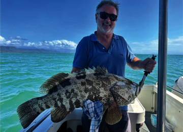 Angler holding a freshly caught grouper